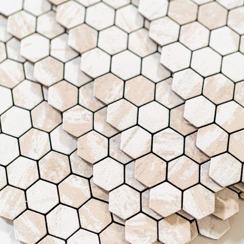 Creating a Stylish Backsplash with Peel and Stick Tiles In the process of mounting peel and stick mosaic tiles onto a foam board, perfect for enhancing a food photography studio's aesthetic.